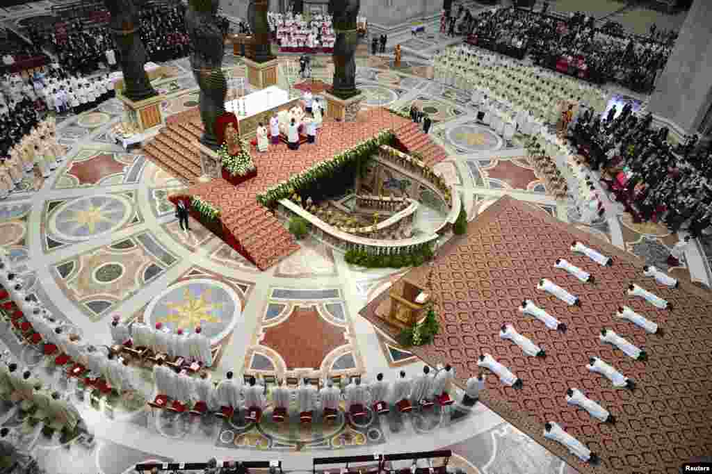 New priests lay on the floor as Pope Francis leads their ordination ceremony during a solemn mass in Saint Peter's Basilica at the Vatican.