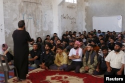 FILE - Rebel fighters from the Ahrar al-Sham Movement take Islamic and Koran lessons inside a camp, during the holy month of Ramadan in Idlib countryside, Syria, July 7, 2015. The group pulled out of a meeting of opposition groups in Saudi Arabia, Dec. 10