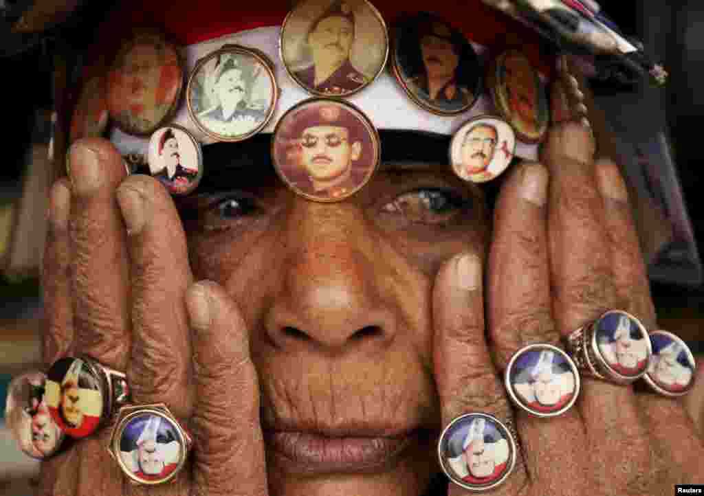 A woman supporting Yemen's former President Ali Abdullah Saleh, wears a pin with an image of Saleh's son Ahmed Ali Abdullah Saleh (C), during a rally against airstrikes, in Sanaa.