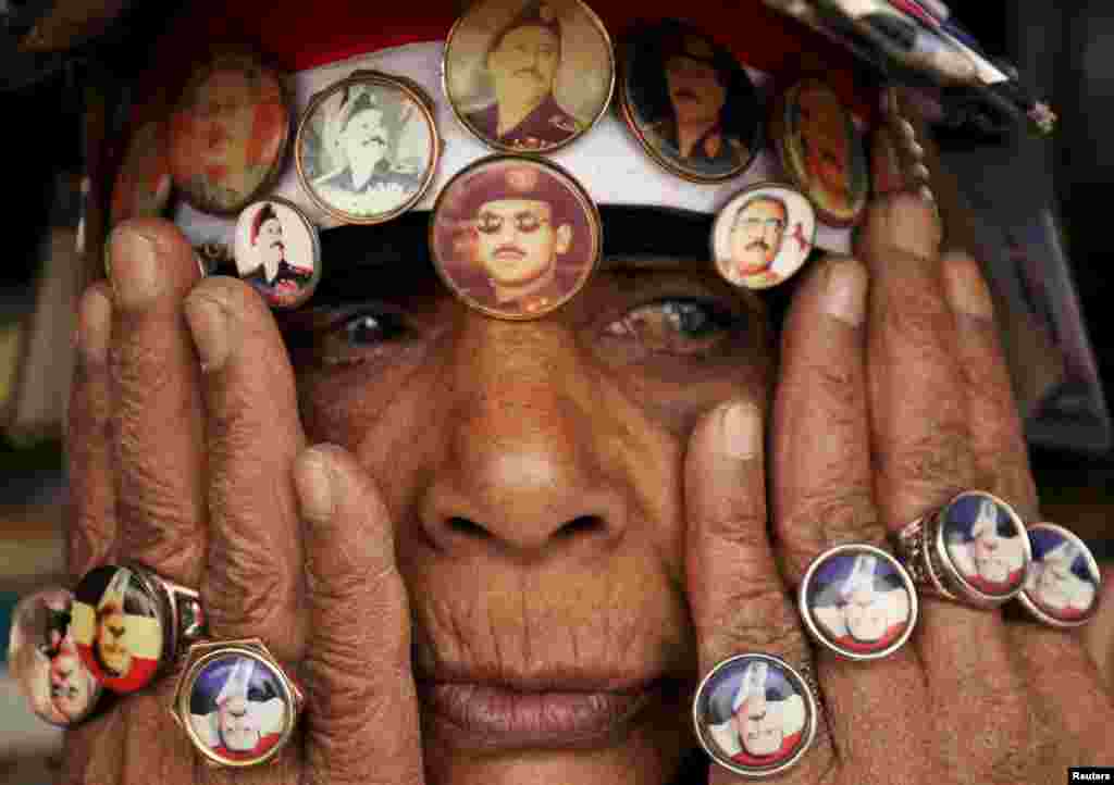 A woman supporting Yemen&#39;s former President Ali Abdullah Saleh, wears a pin with an image of Saleh&#39;s son Ahmed Ali Abdullah Saleh (C), during a rally against airstrikes, in Sanaa.