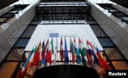 FILE - Flags are seen inside the European Council headquarters on the eve of a EU Summit in Brussels, Belgium.