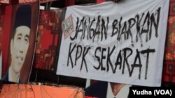 Seorang warga tengah memasang spanduk bertuliskan pesan agar Presiden "Jangan Biarkan KPK Sekarat" di Solo, 18 Februari 2015 (Foto: VOA/Yudha).