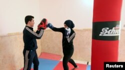 Abdul Zahra, praktisi tinju dan karate lokal Irak (36 tahun), berlatih bersama putranya di rumahnya di Najaf, Irak, 24 Desember 2021. (REUTERS/Alaa Al-Marjani)