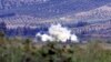 Smoke rises after a mortar bomb fired from Syria landed on Turkish soil on the Turkish-Syrian border in southern Hatay province, October 8, 2012.