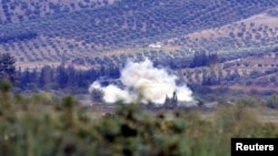 Smoke rises after a mortar bomb fired from Syria landed on Turkish soil on the Turkish-Syrian border in southern Hatay province, October 8, 2012.