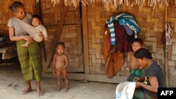 ພາບນີ້ຖ່າຍໃນວັນທີ 10 ມີນາ 2011 ສະແດງໃຫ້ເຫັນແມ່ຍິງ ແລະ ລູກນ້ອຍ ຢູ່ໜ້າເຮືອນຫຼັງນຶ່ງໃນໝູ່ບ້ານຂອງຊົນເຜົ່າ ກຶມມຸ, ແຂວງຫຼວງນໍ້າທາ.