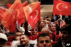 FILE - Supporters of Turkey's President Recep Tayyip Erdogan wave flags as they listen to him speak during a Justice and Development Party election rally in Istanbul, May 29, 2018.