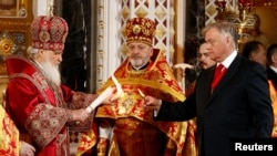 Патриарх Кирилл (слева) проводит праздничную службу в Храме Христа Спасителя в Москве. Россия