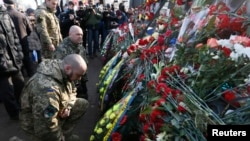 People attend a commemoration ceremony at the monument of the so-called "Nebesna Sotnya" (Heavenly Hundred), the anti-government protesters killed during the Ukrainian pro-European Union (EU) mass protests in 2014, during a rally marking the third anniver