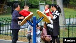 浙江省金华市一个花园里的妇女与儿童在做游戏。（2018年11月5日）