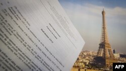 An illustration picture taken on Dec. 10, 2015 in Paris shows a draft for the outcome of the COP21 United Nations conference on climate change next to a picture of the Eiffel Tower. 