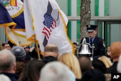Firefighter James Sorokac, of the Fire Dept. of New York Ceremonial Unit, rings a bell marking the time of the 1993 World Trade Center, during the 25th anniversary ceremony at the 9/11 Memorial to commemorate the six victims, in New York, Feb. 26, 2018.