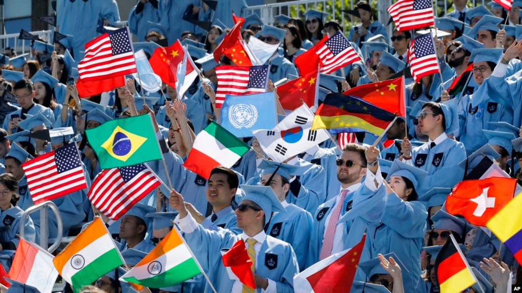 FILE - Columbia University students celebrate at the graduation ceremonies in 2019. A recent lawsuit claims Columbia and 15 others have worked together to limit financial aid to students. (AP Photo/Mark Lennihan)