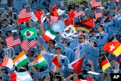 Students in the School of International and Public Affairs wave flags at Columbia University's commencement, Wednesday, May 22, 2019 in New York. More than 14,000 undergraduate and graduate students at the university have completed their studies. (AP Phot