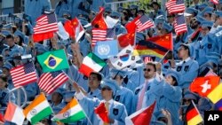 FILE - Columbia University students celebrate at the graduation ceremonies in 2019. A recent lawsuit claims Columbia and 15 others have worked together to limit financial aid to students. (AP Photo/Mark Lennihan)