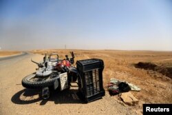 A motorcycle used by Islamic State militants is left on the road during the war between Iraqi army and Shi'ite Popular Mobilization Forces (PMF) against the Islamic State militants in al-Ayadiya, northwest of Tal Afar, Iraq, Aug. 28, 2017.