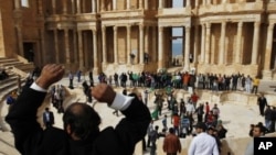 A man leads a chant by supporters of leader Moammar Gadhafi at a Roman amphitheatre in Sabratha, 75 km (46.6 miles) west of Tripoli, February 28, 2011