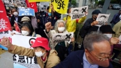 People chant slogans against government's decision to start releasing massive amounts of treated radioactive water from the wrecked Fukushima nuclear plant into the sea, during a rally outside the prime minister's office in Tokyo Tuesday, April 13, 2021.