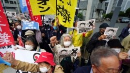 People chant slogans against government's decision to start releasing massive amounts of treated radioactive water from the wrecked Fukushima nuclear plant into the sea, during a rally outside the prime minister's office in Tokyo Tuesday, April 13, 2021.