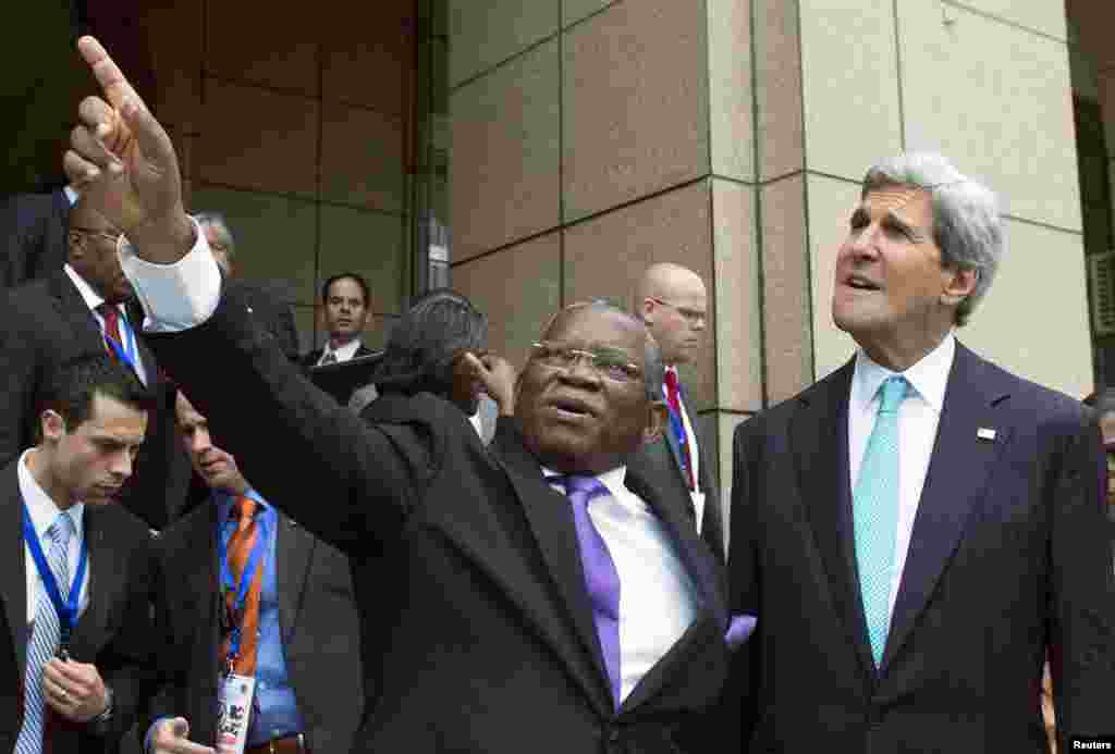 O ministro angolano dos Negócios Estrangeiros, Georges Chikoti, à esquerda, mostra um dos edifícios do Governo ao Sec. Estado americano, John Kerry, à saída do Ministério das Finanças em Luanda, 5 de Maio, 2014