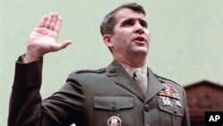 FILE - Oliver North is sworn in on Capitol Hill in Washington prior to testifying before the House Foreign Affairs Committee, Dec.18, 1986.