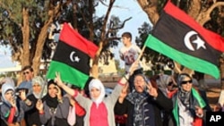 Libyans greet rebel fighters upon their arrival in Benghazi from Sirte on October 22, 2011.