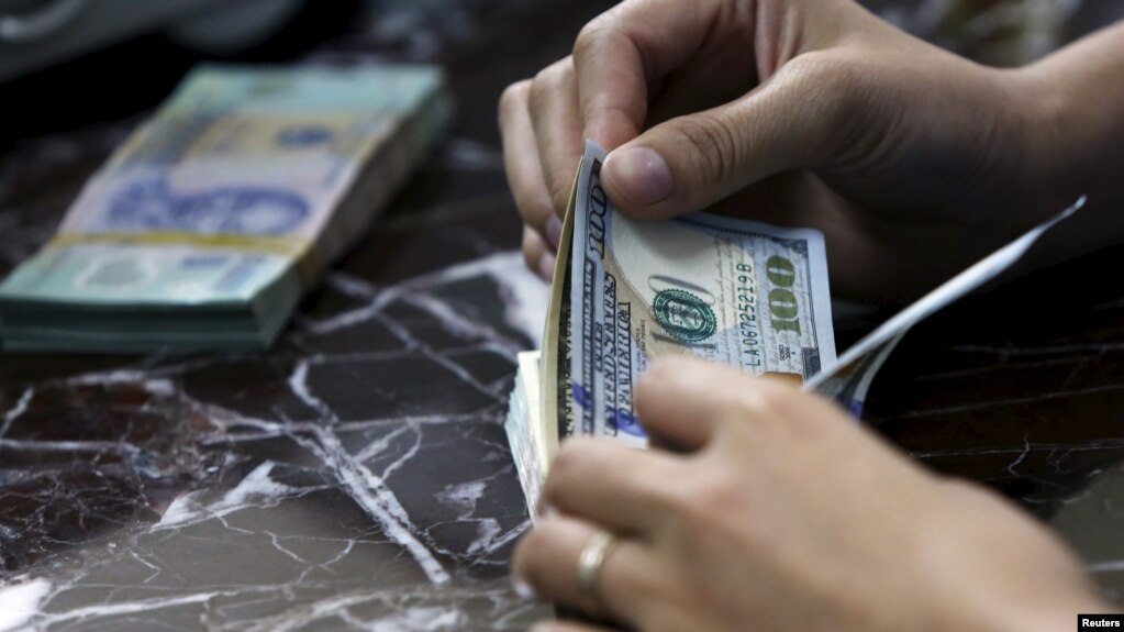 Nhân viên ngân hàng đếm đồng đôla Mỹ tại một ngân hành ở Hà Nội, ngày 12/08/2015. 