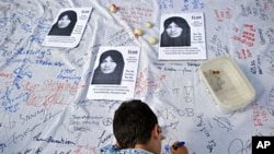 A boy signs a petition calling for an end to stoning during a demonstration by members of the International Committee Against Stoning in London, demanding the release of Sakineh Ashtiani, 24 Jul 2010