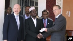 Somali President Sharif Sheik Ahmed, center, receives diplomatic credentials from British ambassador to Somalia Matt Baugh, right, and British Foreign Secretary William Hague, at Mogadishu's presidential palace, February 2, 2012.