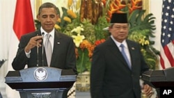 US President Barack Obama, left, adjusts a microphone as Indonesian President Susilo Bambang Yudhoyono walks behind before a joint press conference at the Presidential Palace in Jakarta, Indonesia, 09 Nov 2010