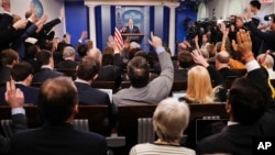 FILE - Reporters raise their hands as White House press secretary Sean Spicer takes questions during the daily briefing in the Brady Press Briefing Room of the White House in Washington, Feb. 22, 2017.