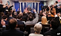 FILE - Reporters raise their hands as White House press secretary Sean Spicer takes questions during the daily briefing in the Brady Press Briefing Room of the White House in Washington.