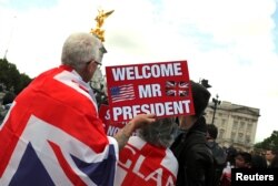 Orang-orang menunggu di depan Istana Buckingham saat Presiden Trump dan istrinya, Melania, berkunjung.