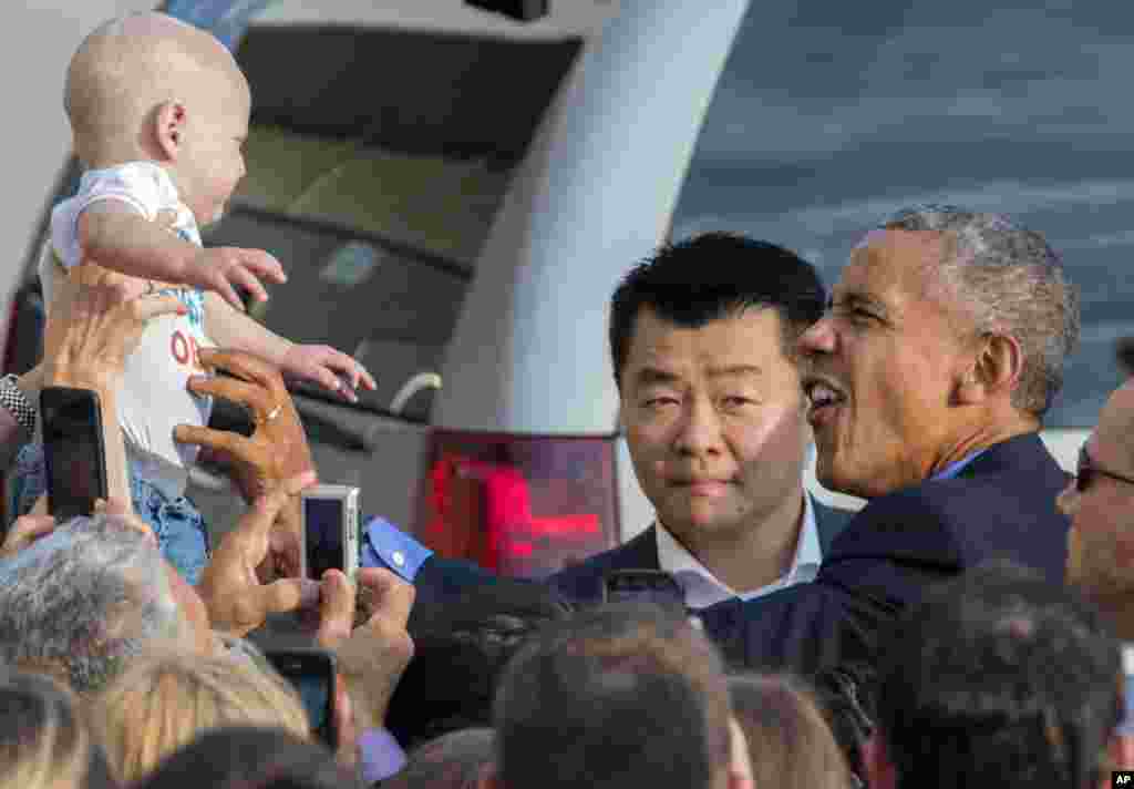 While greeting well wishers after arriving at John F. Kennedy International Airport in New York, President Barack Obama reaches out to Desmond Hatfield-Rudin, eight-month-old, of the Brooklyn borough of New York, Sept. 18, 2016.
