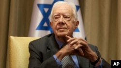 FILE - Former U.S. President Jimmy Carter sits prior to a meeting with Shimon Peres, then Israel's president, in Jerusalem, Oct. 21, 2012. 