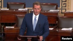 FILE - U.S. Senator Jeff Flake, R-Ariz., speaks on the Senate floor in Washington, Oct. 24, 2017. He says he's had a "long-term interest" in Zimbabwe and thinks President Robert Mugabe will go down in history "as a long-serving thug."