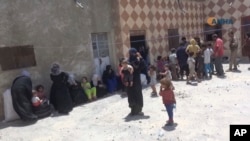 This frame grab from vide provided by Hawar News Agency, a Syrian Kurdish activist-run media group, shows residents gathering in a house after liberated by the U.S.-backed Syrian Democratic Forces (SDF) fighters in the eastern side of Raqqa, Syria, July 6