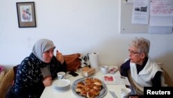 Amnah Hamad, left, who is from Palestine and has lived in Denmark for 30 years, learns to speak Danish from teacher Anni Olsen who, as part of a group of seniors, volunteers to teach Danish to immigrants in Mjolnerparken, Copenhagen, Denmark, May 1, 2018.