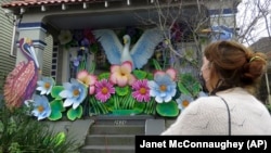 Caroline Thomas is a designer looking at a house decorated like a parade float in New Orleans for Mardi Gras, on Friday, Jan. 8, 2021. (AP Photo/Janet McConnaughey)