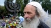 FILE - People lay flowers at a menorah monument close to the Babi Yar ravine where the Nazis machine-gunned tens of thousands of Jews during WWII, in Kyiv, Ukraine, Sept. 30, 2012.