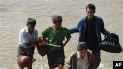 Burmese citizens cross the Moei river as they flee Myawaddy township in Burma's to Thailand's Mae Sot town, 08 Nove. 2010, following fighting between Burmese soldiers and ethnic Karen fighters.