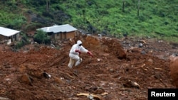 A rescue worker is seen at the scene of the mudslide in the mountain town of Regent, Sierra Leone, Aug. 16, 2017. 