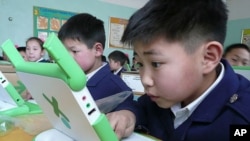 A boy in Mongolia checks out his computer after receiving it from 'One Laptop Per Child'.