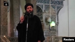 Image taken from recently released video shows man purported to be Abu Bakr al-Baghdadi, ISIL's reclusive leader, making what would be his first public appearance at a mosque in the center of Iraq's second city, Mosul July 5, 2014.