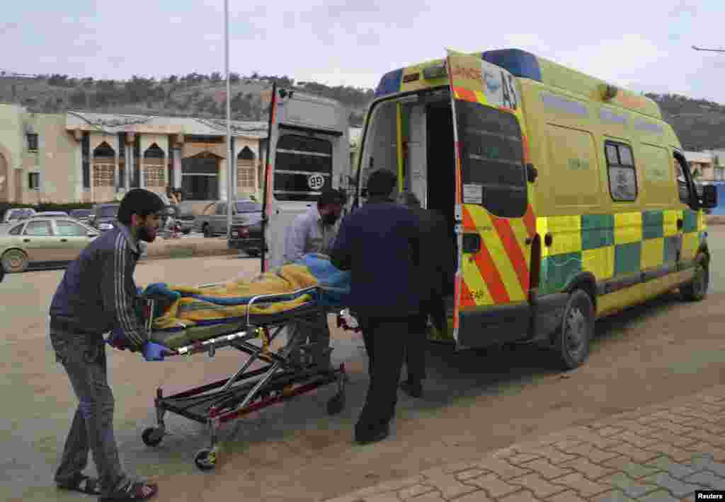 Men transport a casualty after car bomb attacks at the Bab al-Hawa border crossing between Syria and Turkey, in Idlib, Jan. 20, 2014. 