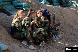 Iranian-Kurdish female fighters hold their weapons during a battle with Islamic State militants in Bashiqa, near Mosul, Iraq Nov. 3, 2016.