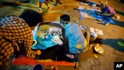 FILE - People paint a portrait of Freddie Gray at a housing complex where he was arrested, May 3, 2015, in Baltimore, Maryland.