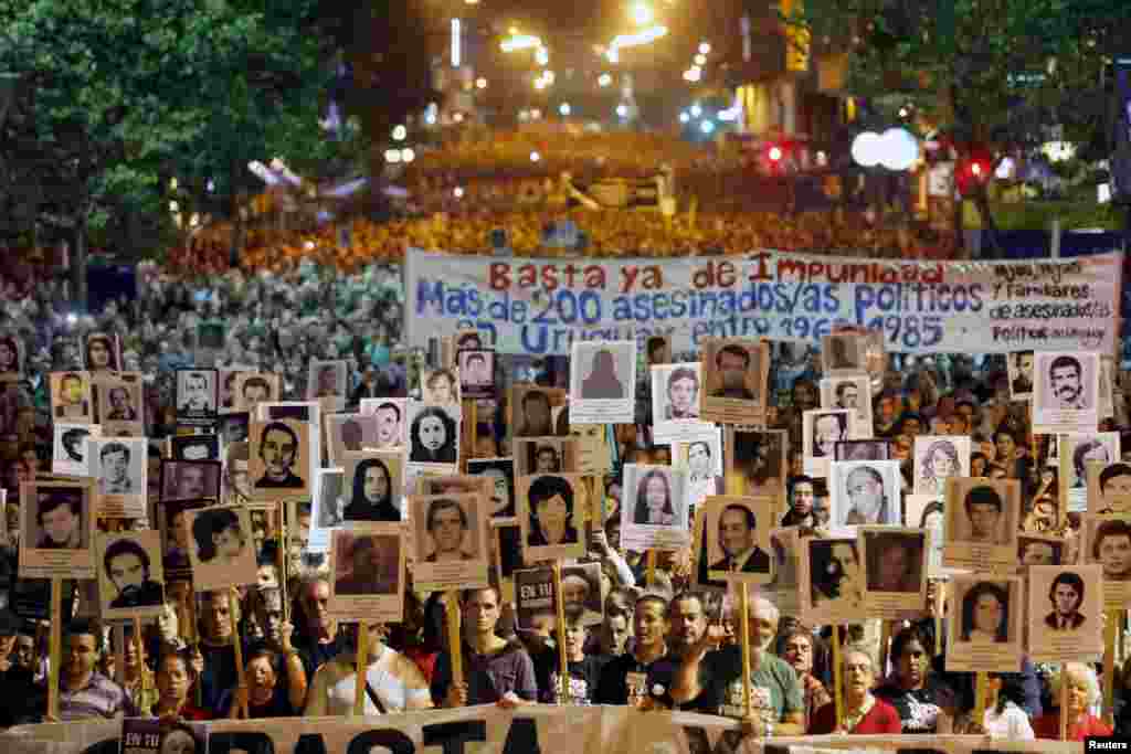 Uruguayans display pictures of their relatives who &quot;disappeared&quot; during the rule of the military regime (1973-1985), at an annual demonstration in Montevideo, May 20, 2015. Thousands of Uruguayans marched along 18 de Julio, the main avenue of the city, demanding to know about the more than 150 missing Uruguayans that they said were kidnapped by military forces.