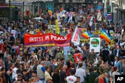 Protesters carry effigies of US President Donald Trump and Belgian PM Charles Michel during a demonstration in the center of Brussels on May 24, 2017.