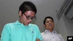 Mulyadi Budiman (kiri) dikawal seorang petugas imigrasi untuk menghadiri konferensi pers di Bangkok, Thailand (2/4).
